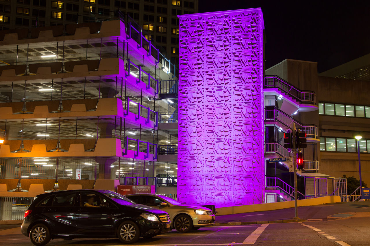 View of Wickham Terrace Car Park with purple creative lighting facing street at night.